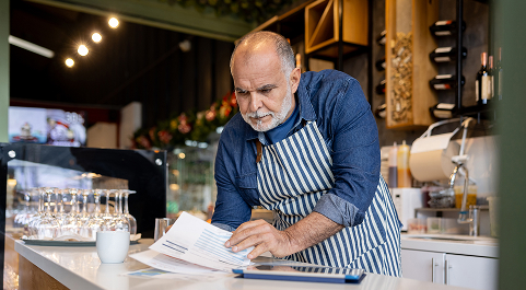 Business owner reviewing bill at lunch counter 