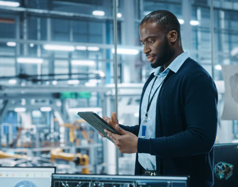 Cuple smiling while drying the dishes and a smart thermostat in the background