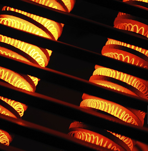 Cuple smiling while drying the dishes and a smart thermostat in the background