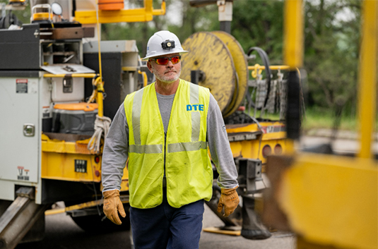 DTE Lineman in yard wearing hard hat