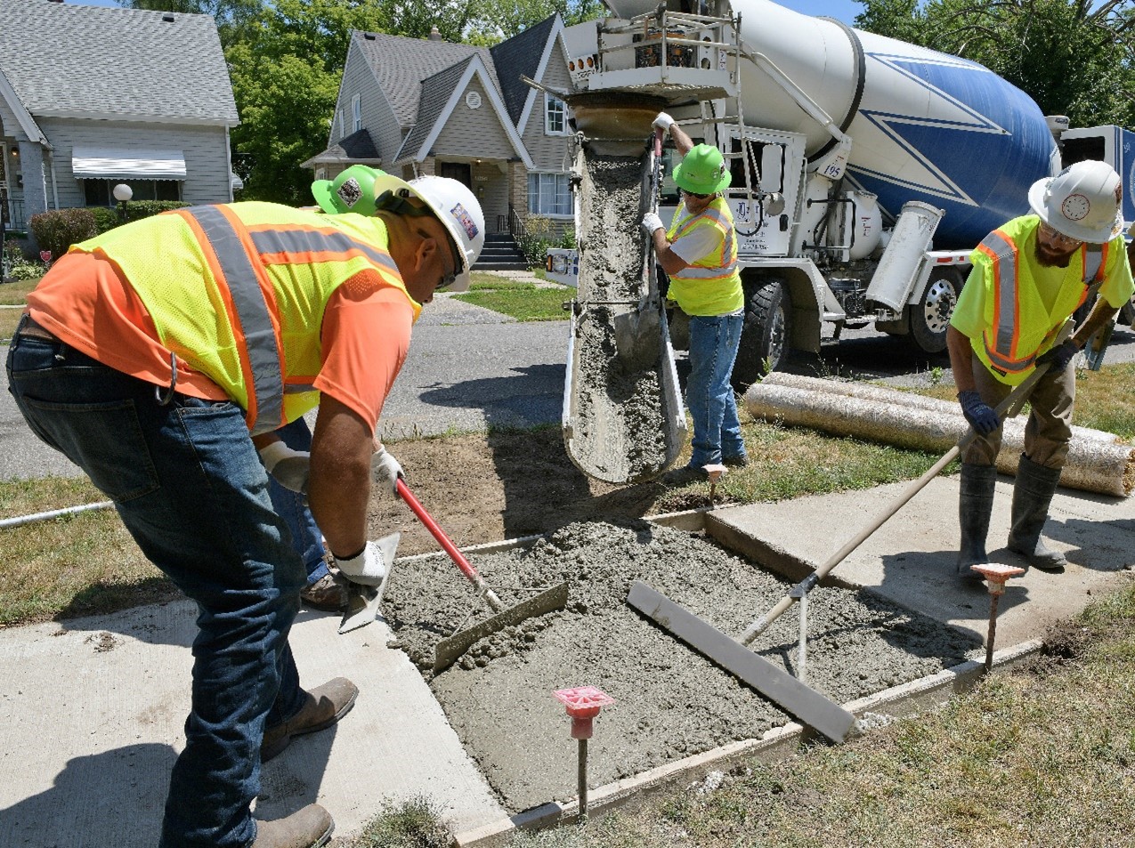 DTE service technicians laying new cement for a sidewalk