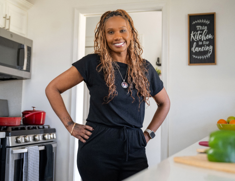DTE Employee standing in her kitchen in front of fresh vegetables ready to prepare a meal
